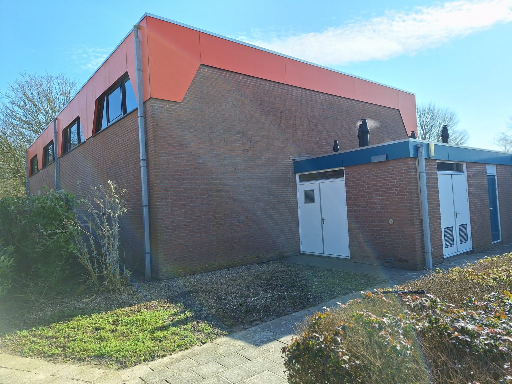zijkant vna gymzaal met oranje boarding