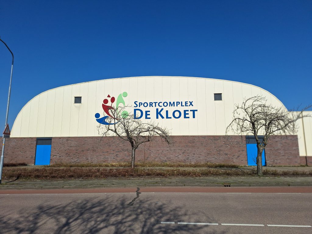 zijkant van sportgebouw met naam